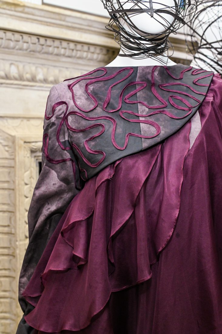embroidery detail on burgundy taffeta dress on mannequin