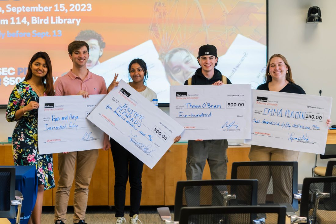 2023 Ideas Fest student winners standing with giant checks