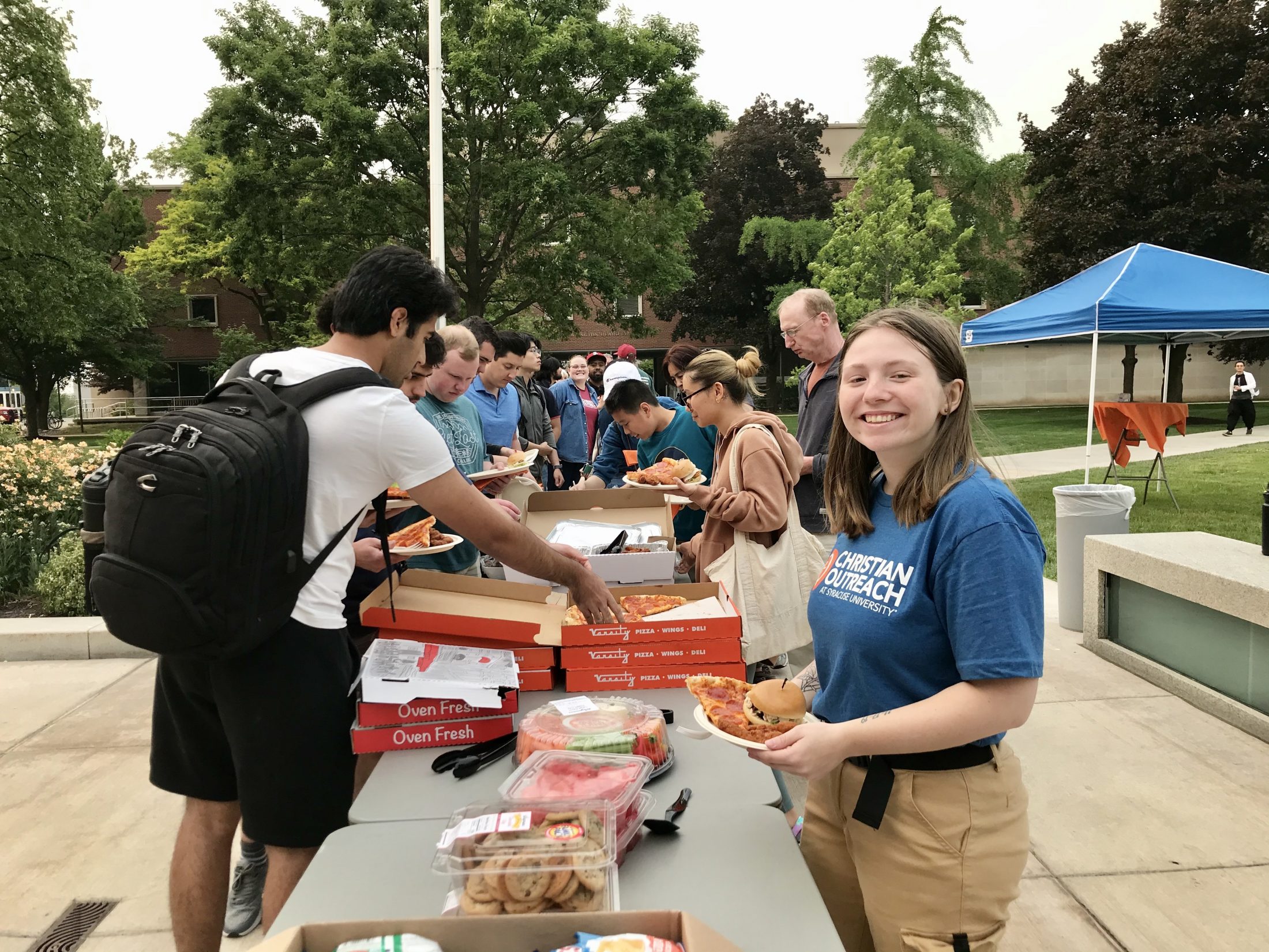 Christian students eat pizza and dinner on Syracuse University's quad.