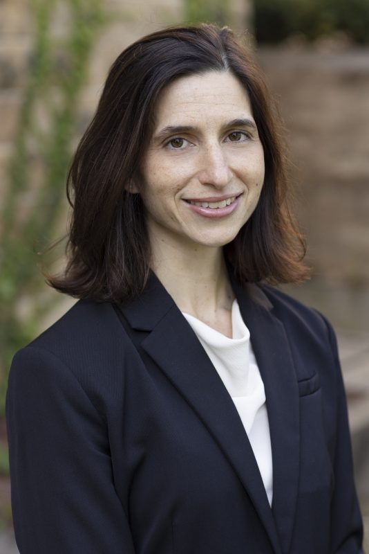 A white woman in a dark suit.