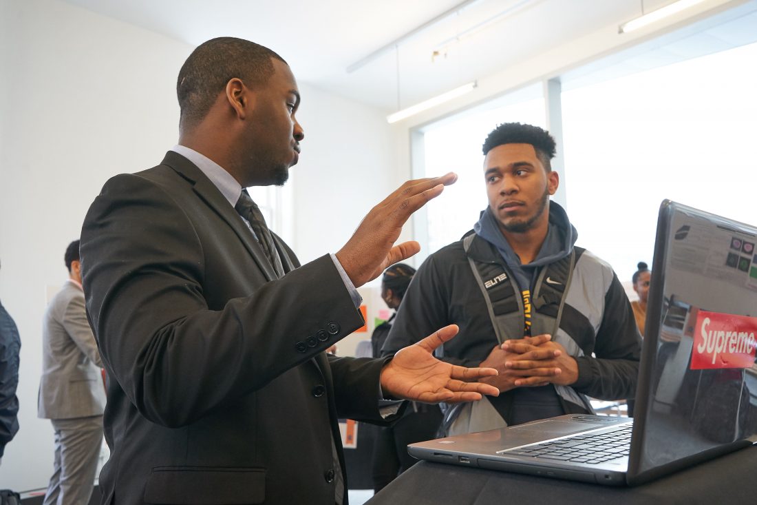 Student presents their research to a peer at the 2019 scholars of distinction showcase