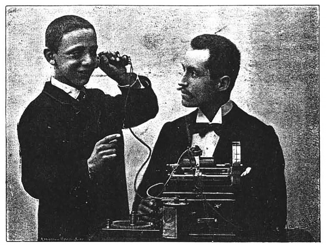 An antique photograph of person listening to an early sound device