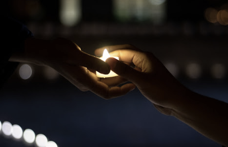 Hands exchanging Diwali tealight in the Orange Grove. Photo courtesy Marijke Margaret Stivers Pieters-Kwiers 