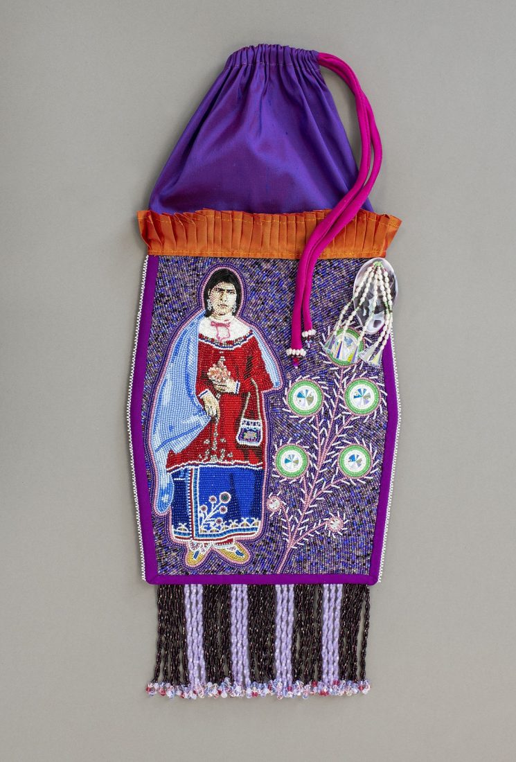 Purple oblong drawstring pouch with tassels at bottom and beadwork in middle depicting a person on the left and plant on the right