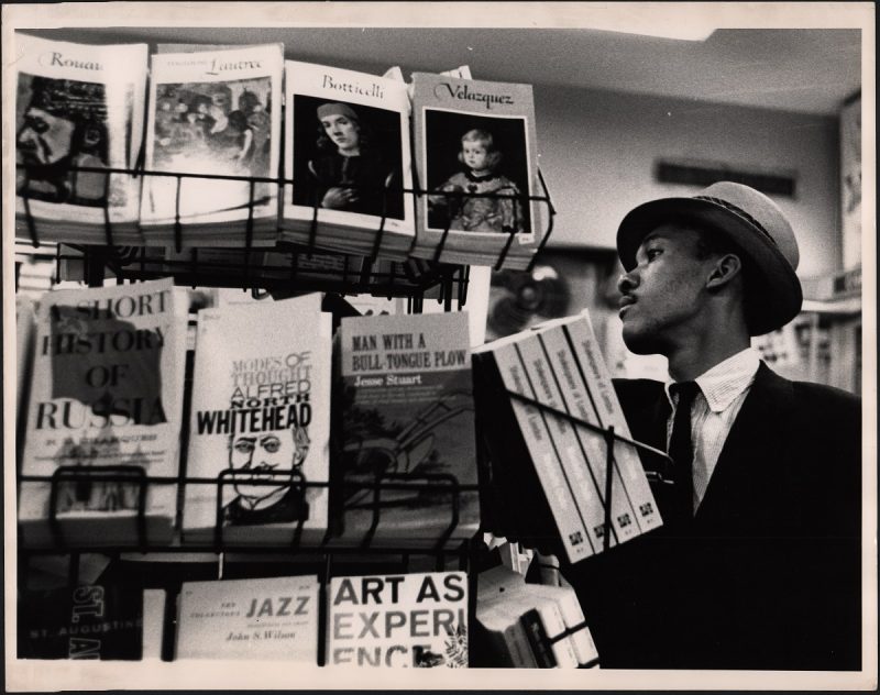 Black and white photo of a man in a bookstore