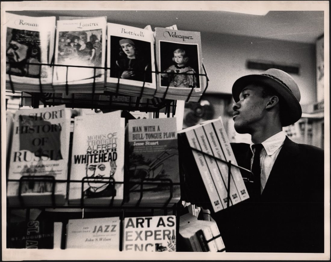 Black and white photo of man in bookstore