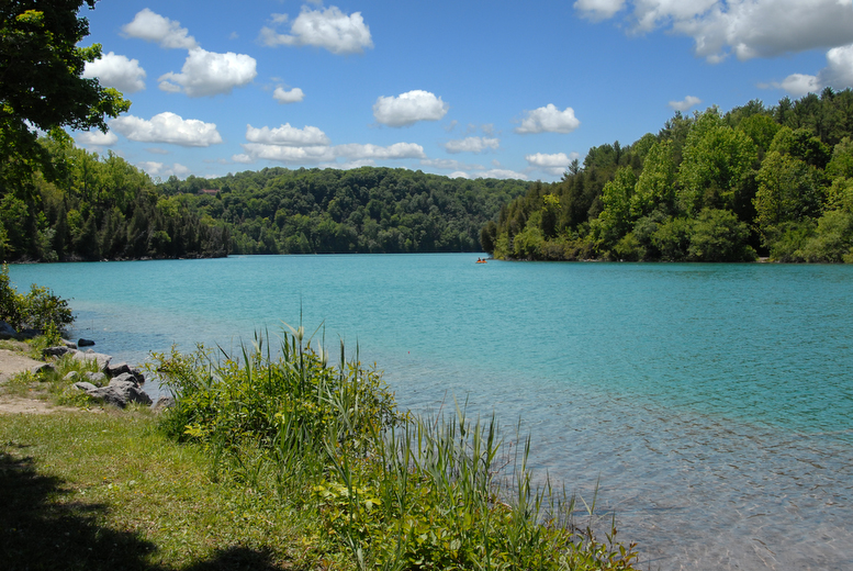 Image of a blue colored lake surrounded by green trees at Green Lakes State Park.