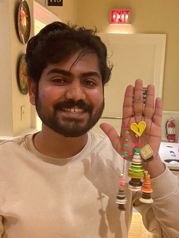 International student holding Holiday ornaments that they have made