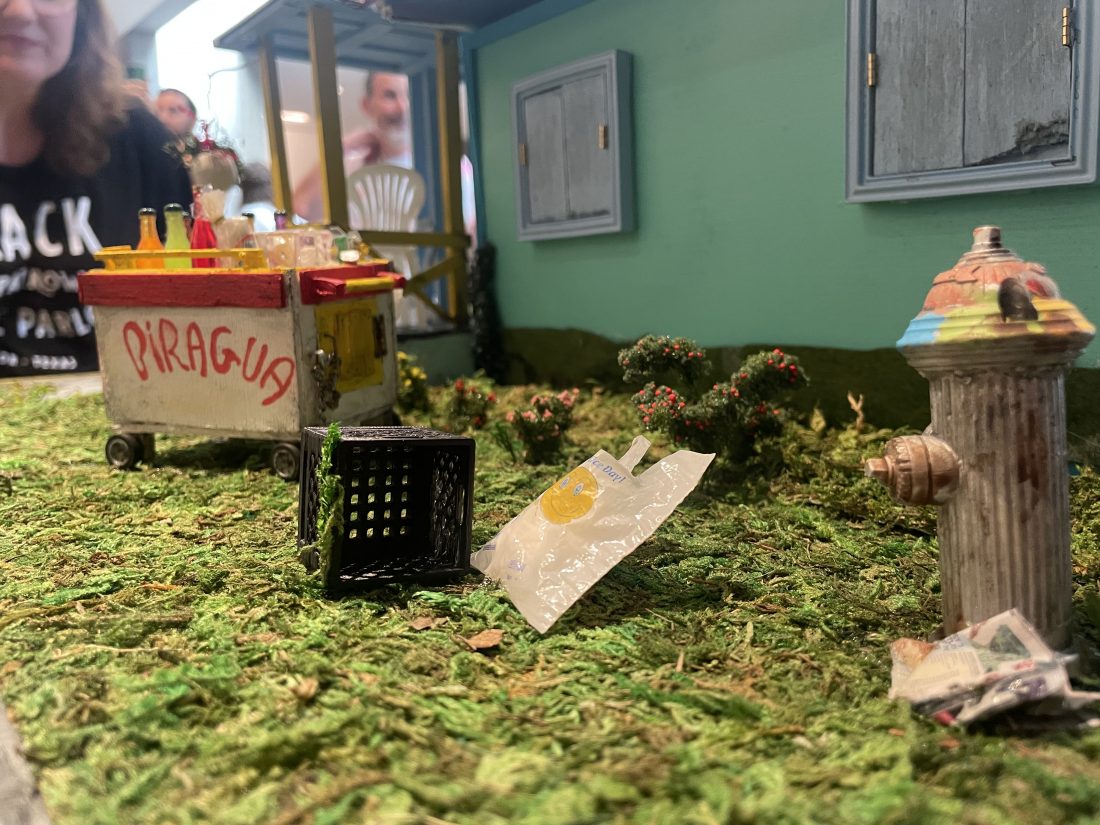 Miniature diorama depicting a drink cart, shopping bag and fire hydrant from the 