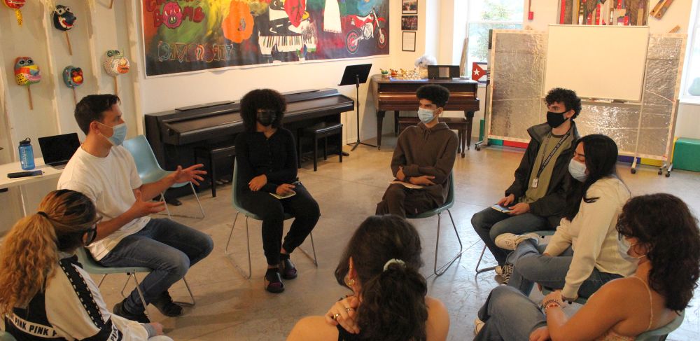 small group sits and chats in a circle at Lacasita Cultural Center