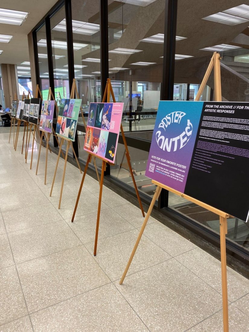 posters set up on easels near glass stairwell of Bird Library