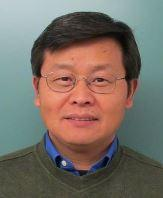 Professor Sean Ling is shown in a sweater over a collared shirt with glasses.