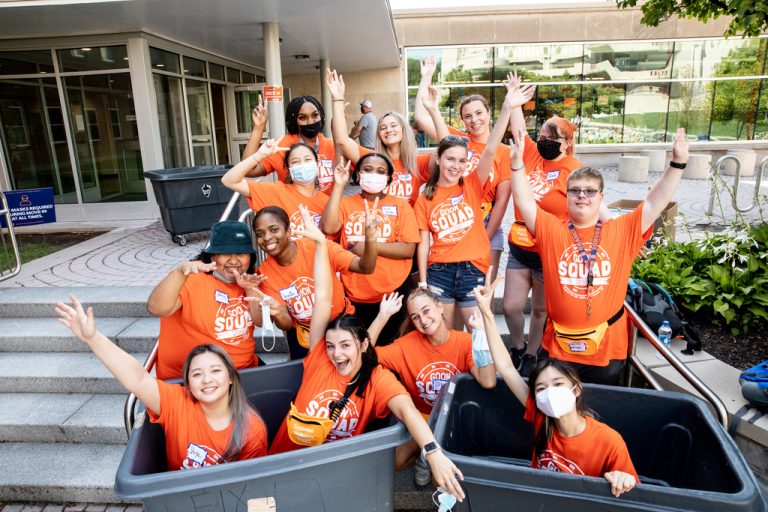 members of the goon squad pushing a moving bin