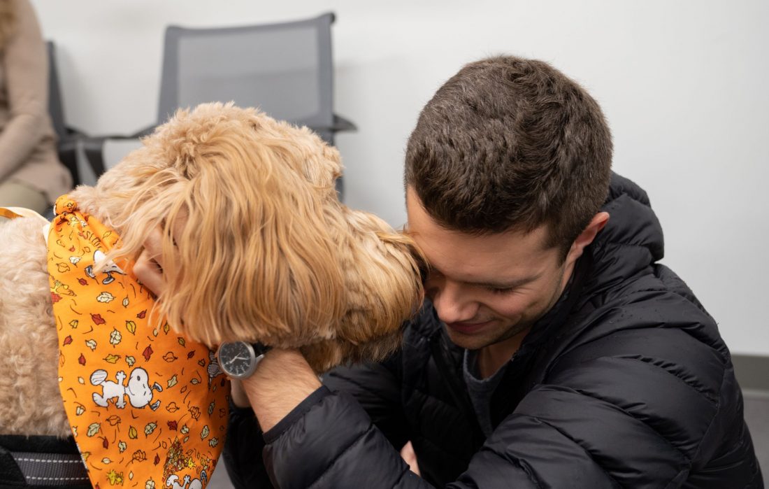 A student lovingly interacts with a therapy dog.