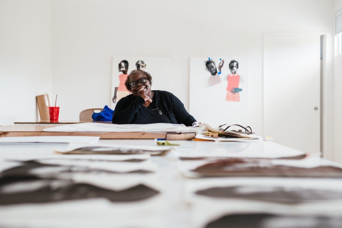 woman at a desk with artwork around her