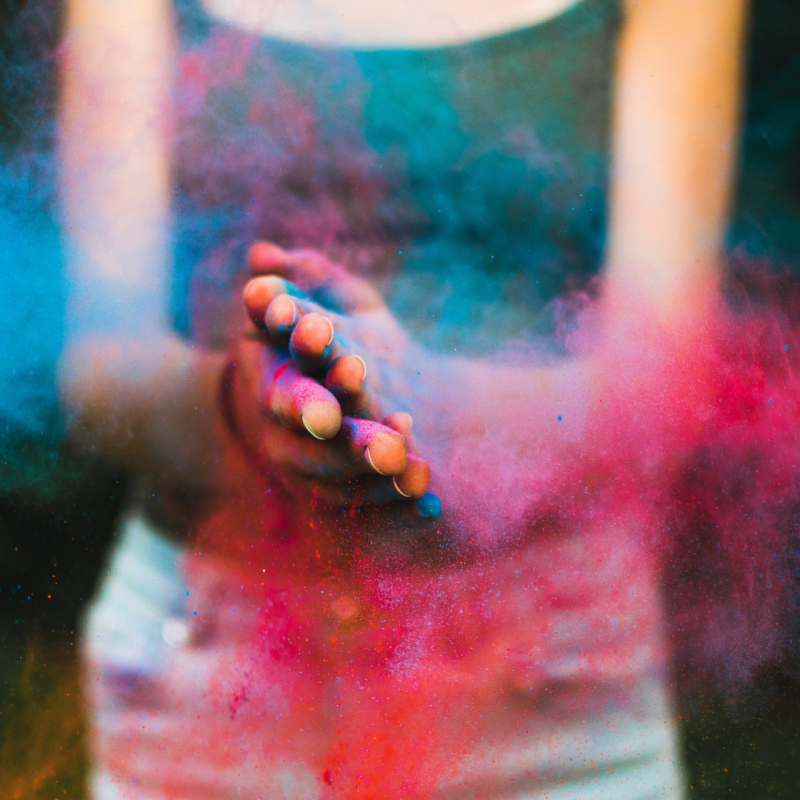 Hands clapping with colorful powder