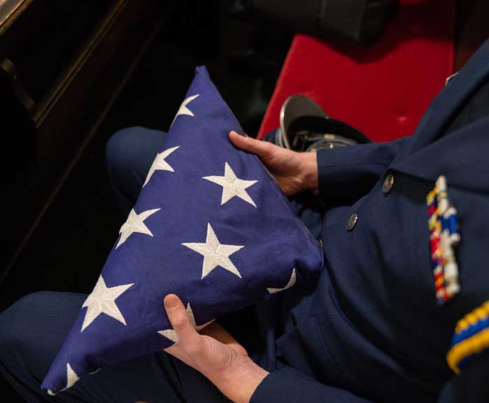 A veteran holds a folded U.S. flas
