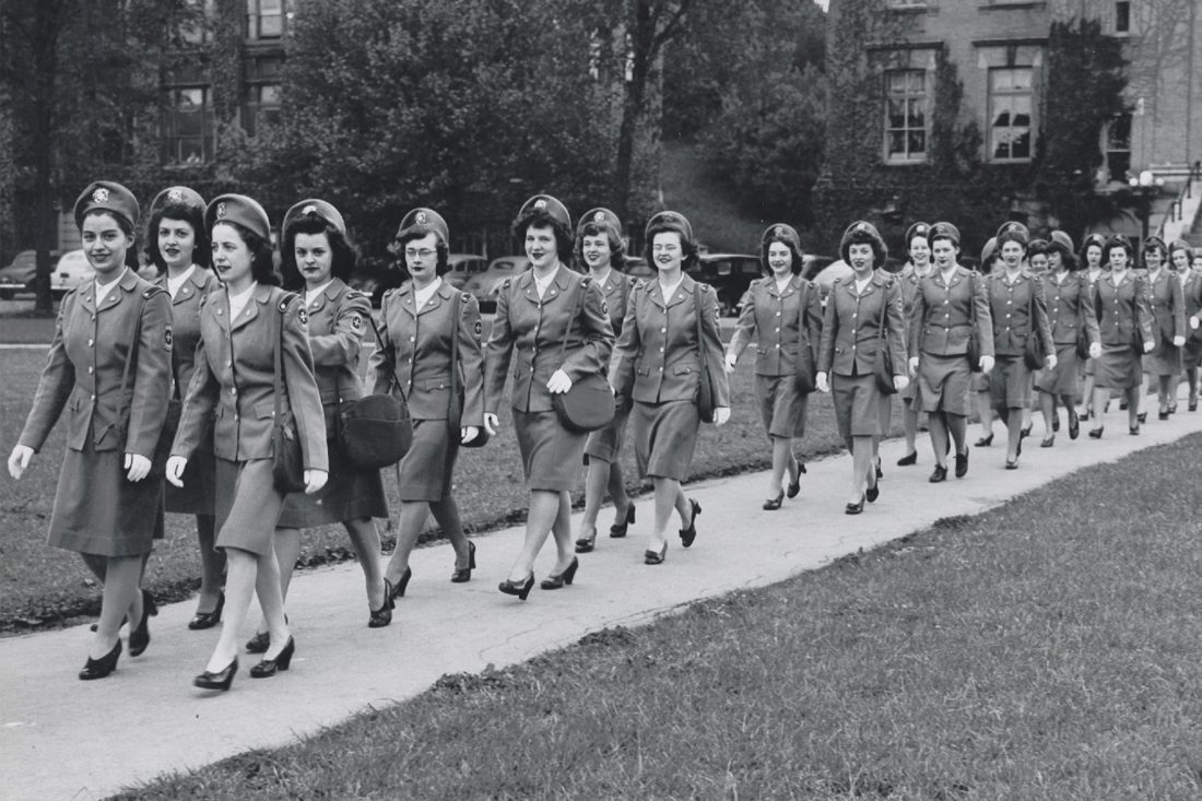 women in uniform walking in unison on campus