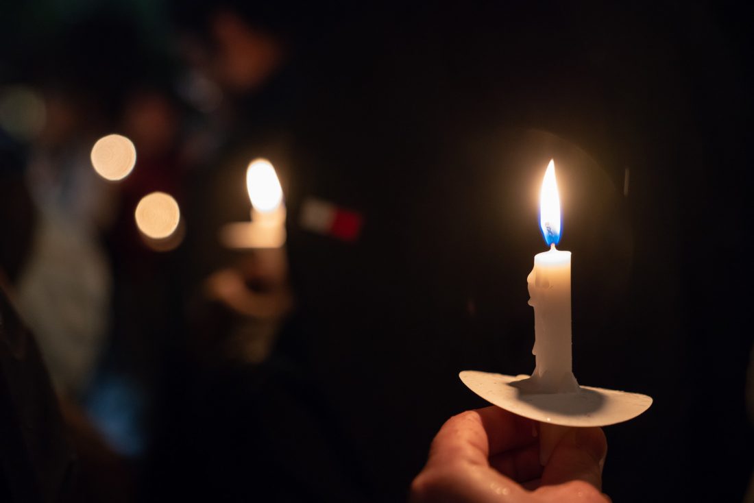 Holding one small lighted candle