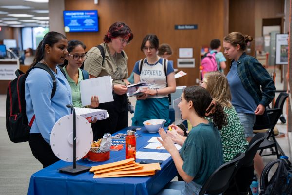 students stopping at tables to learn about services