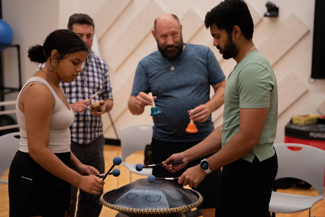 People drumming on various percussive instruments