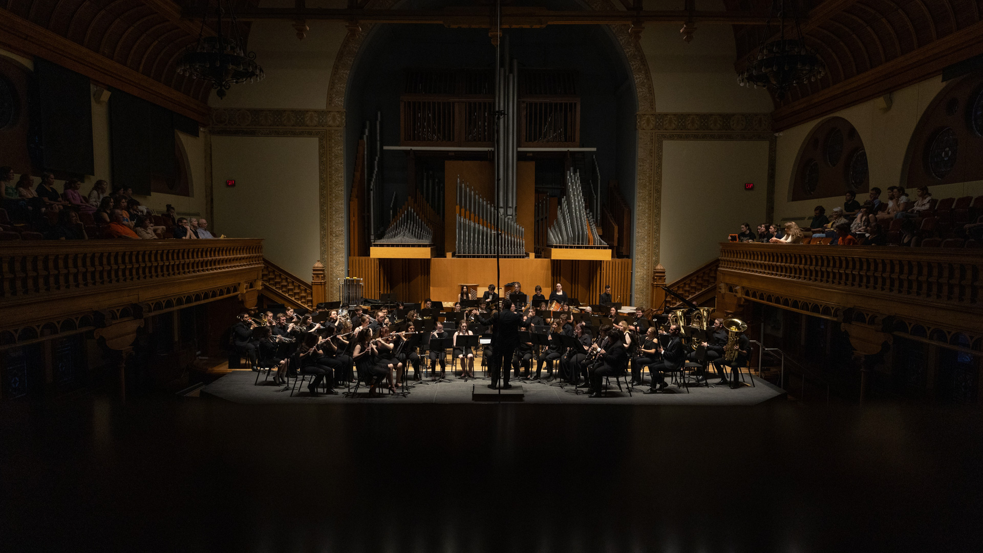 The Syracuse University Wind Ensemble performs on stage.