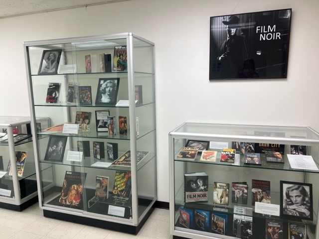 display case with movies, photos, books