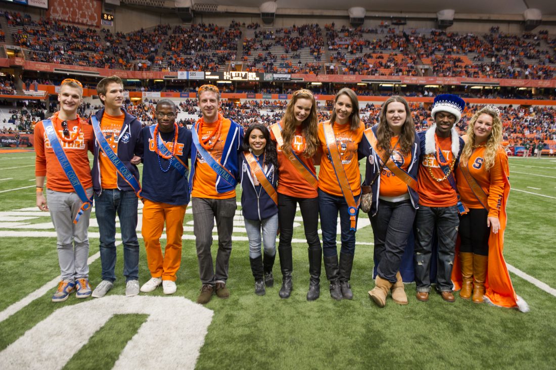 Members of Homecoming Court stand next to each other on Dome turf wearing their Homecoming Court sashes.