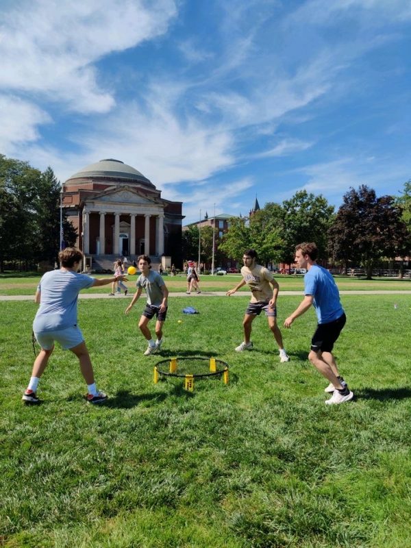 Four students play Spikeball on the Quad