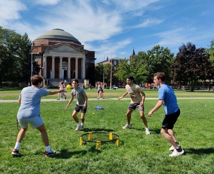 Four students play Spikeball on the Quad