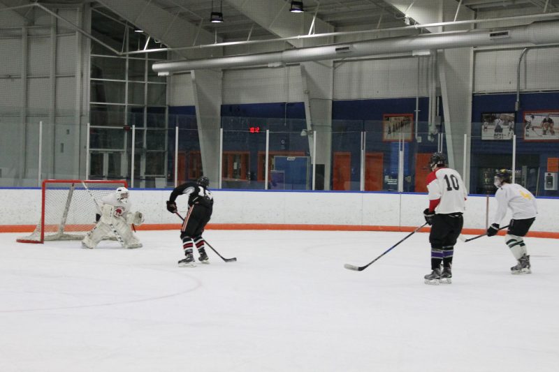 A hockey player attempts to score on a breakaway.