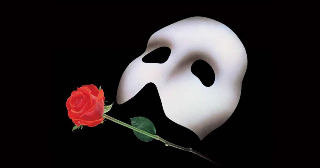 White mask and rose on black background
