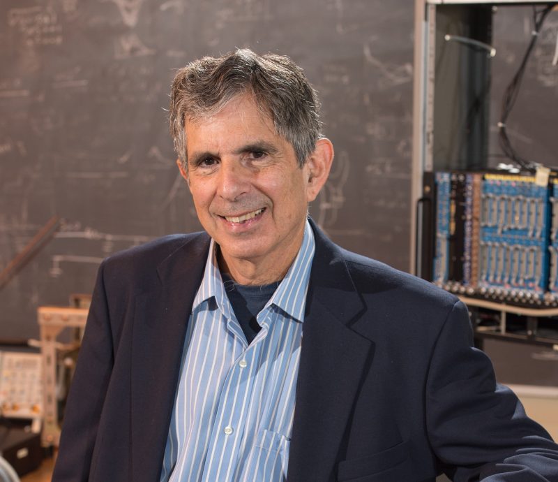 Professor Sheldon Stone shown leaning against a circuit board. Sheldon Stone was a faculty member in the Department of Physics for 30 years.