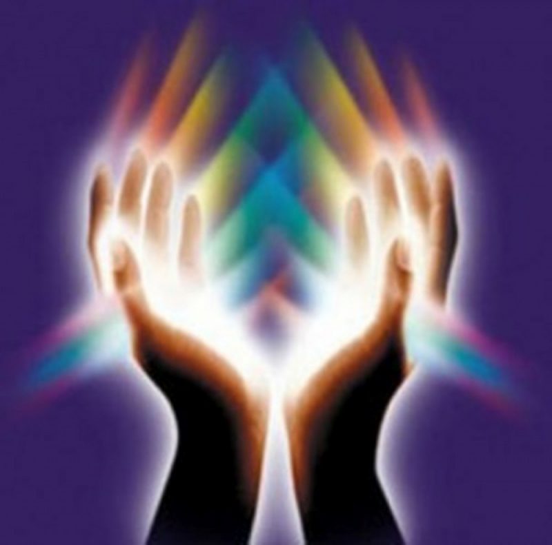 Image of two hands glowing white with prismatic colors coming off of them.