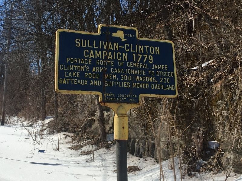 Sullivan-Clinton Campaign 1779 highway marker in New York State. Blue sign with a gold border on the side of the highway in the snow. Image by Steve Stoessel, hmdb.org