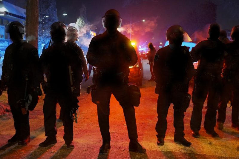 A group of police officers in riot gear at night
