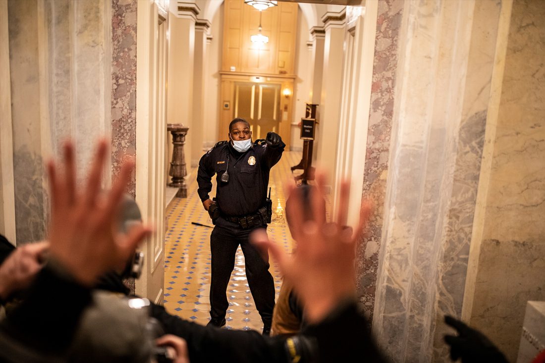 US Capitol Police (USCP) Officer Eugene Goodman confronts protesters as they storm the Capitol in Washington, D.C.