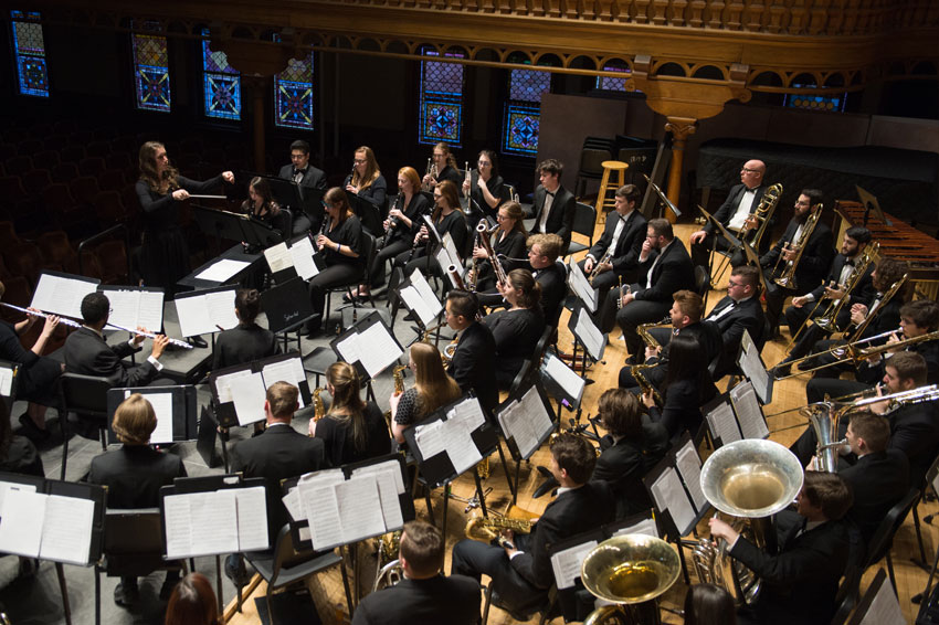 The wind ensemble performs under the direction of a graduate student conductor.